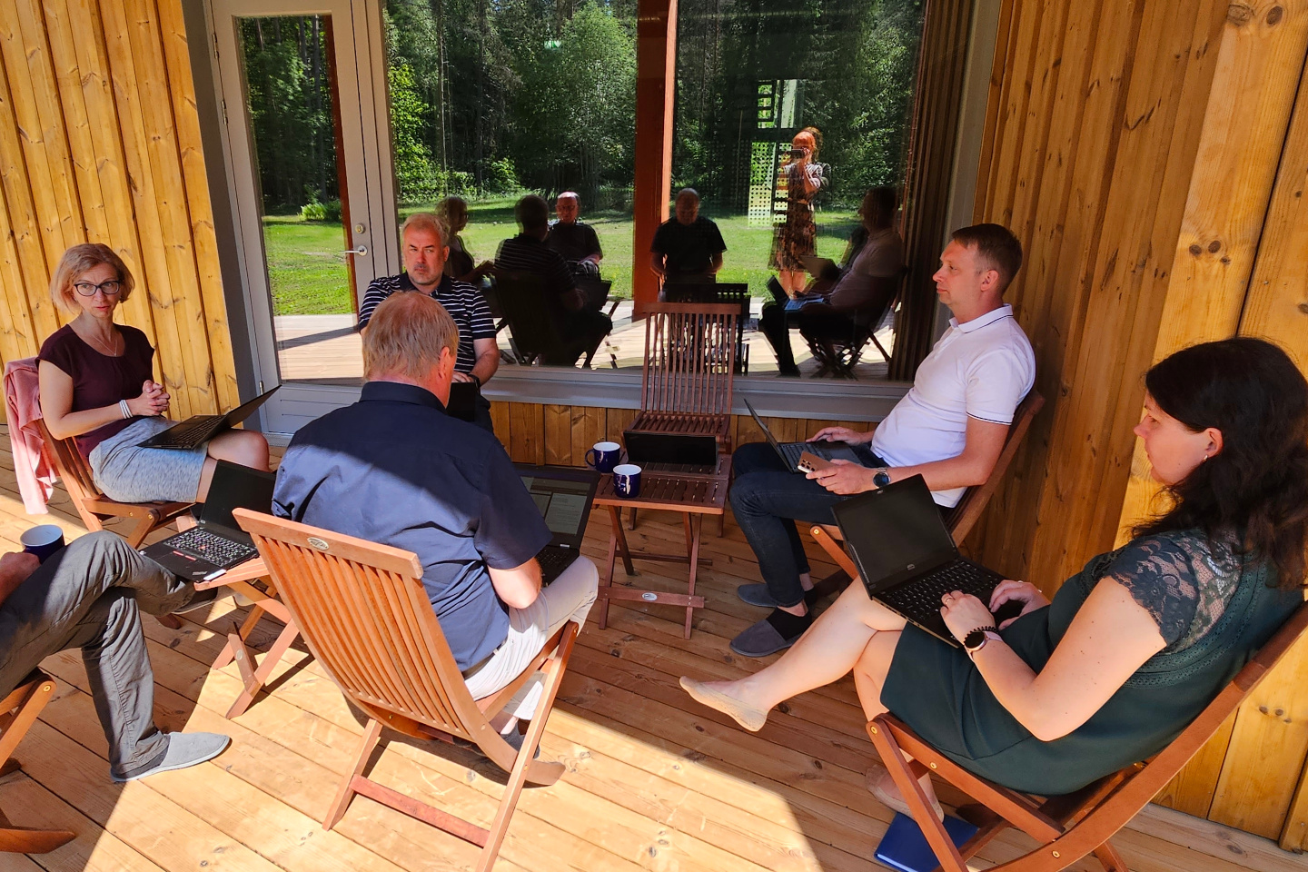 inimesed päikselisel maja terrassil koosolekut pidamas